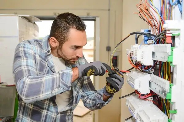 male-electrician-working-on-complex-electrical-panel-or-wiring-system
