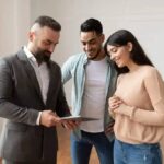 real-estate-agent-showing-an-apartment-listing-on-a-tablet-to-a-young-couple