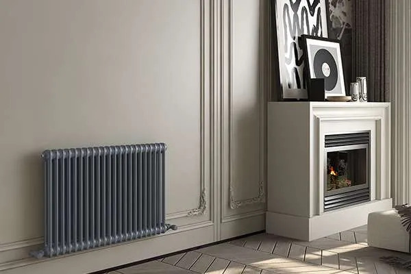 a-dark-gray-horizontal-anthracite-column-radiator-mounted-on-a-light-colored-wall-with-classic-decorative-panel-molding