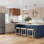 a-large-dark-navy-blue-island-with-thick-white-countertop-sits-in-the-middle-three-backless-wooden-barstools-with-white-frames-stand-tucked-along-the-side