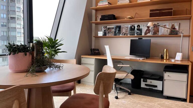 Home Office Decor Ideas for Productivity and Focus a-long-light-wood-built-in-desk-streches-across-a-wall-featuring-an-computer-setup-and-task-lighting