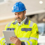 -middle-aged-man-focused-on-a-white-digital-tablet-held-in-his-hands