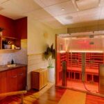 a-modern-wood-framed-sauna-equipped-with-clear-glass-front-wall-and-door-the-interior-glows-with-an-intense-red-light