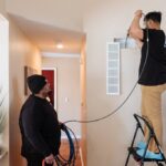 a-professional-air-duct-and-vent-cleaning-service-in-progress-two-technicians-working-in-a-residential-interior