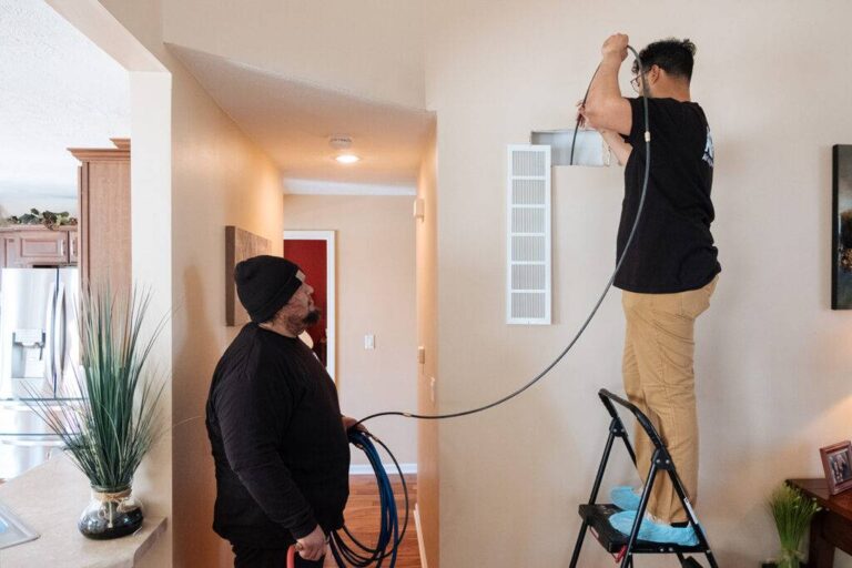 a-professional-air-duct-and-vent-cleaning-service-in-progress-two-technicians-working-in-a-residential-interior