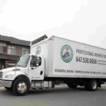 a-white-straight-moving-truck-parked-on-a-paved-residential-street