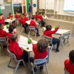 around-10-to-12-young-children-are-visible-they-are-wearing-matching-school-uniforms-consisting-of-red-sweaters