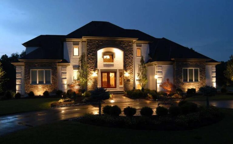 Weather Safety Tips for Landscape Lighting in Knoxville the-home-is-a-multi-story-symmetrical-estate-with-stone-accents-and-a-grand-central-entryway