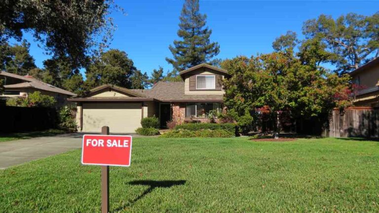 Why Fast Completion Matters When Selling a House a-single-story-suburban-home-with-dark-grey-or-brown-roof-with-light-colored-siding-a-wide-green-lawn-covers-the-foreground