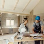 three-construction-professionals-are-active-in-an-unfinished-room-and-renovating-it
