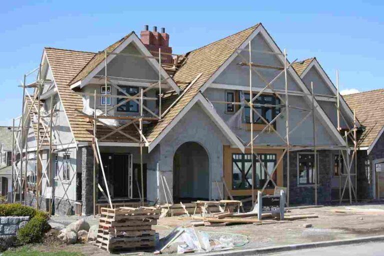 10 Things to Consider Before Building a Custom Home in Colorado Springs a-large-multi-story-residential-house-currently-under-construction-featuring-wooden-and-metal-scaffolding-surrounds-entire-front-of-the-building