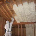 a-professional-worker-applying-spray-form-insulation-to-the-wooden-frame-of-an-attic-or-ceiling