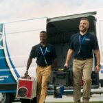 two-male-water-damage-restoration-technicians-are-walking-forward-both-are-holding-piece-of-equipment