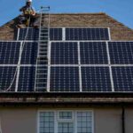 wo-technicians-installing-or-maintaining-a-large-array-of-monocrystalline-solar-panel
